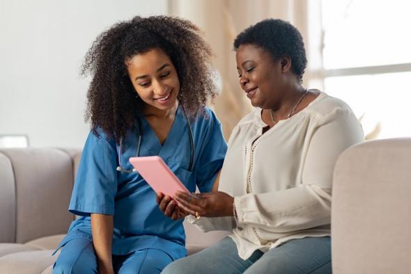 Care vacancies in West Midlands. A female carer helping elderly woman.